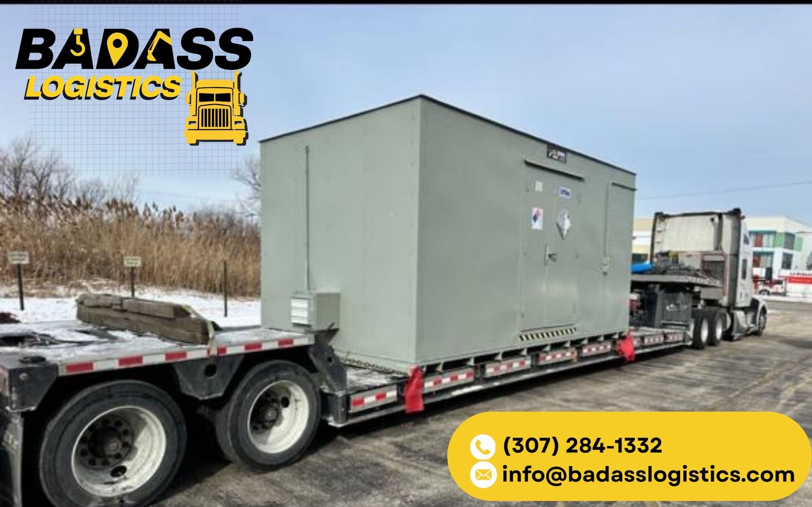 Oversized modular building and electrical enclosure on a lowboy in winter