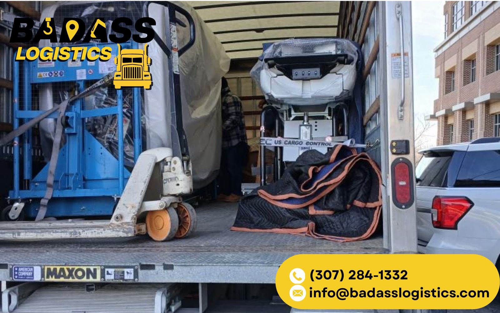 Badass Logistics crew loading a Genie lift and equipment into an enclosed truck