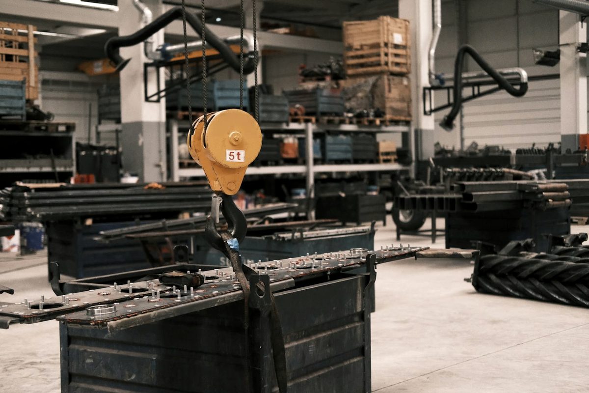 Heavy machine lifted under control by an overhead crane during a rigging move
